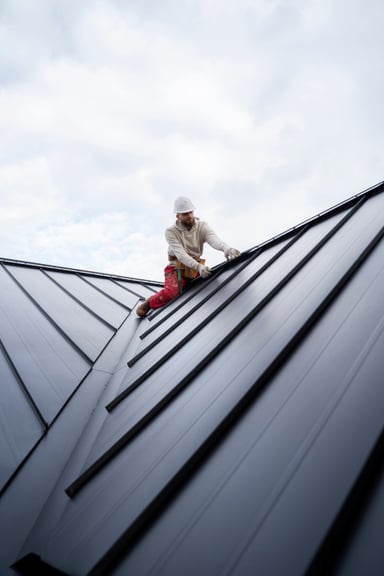 Roofing worker installing metal roof tiles