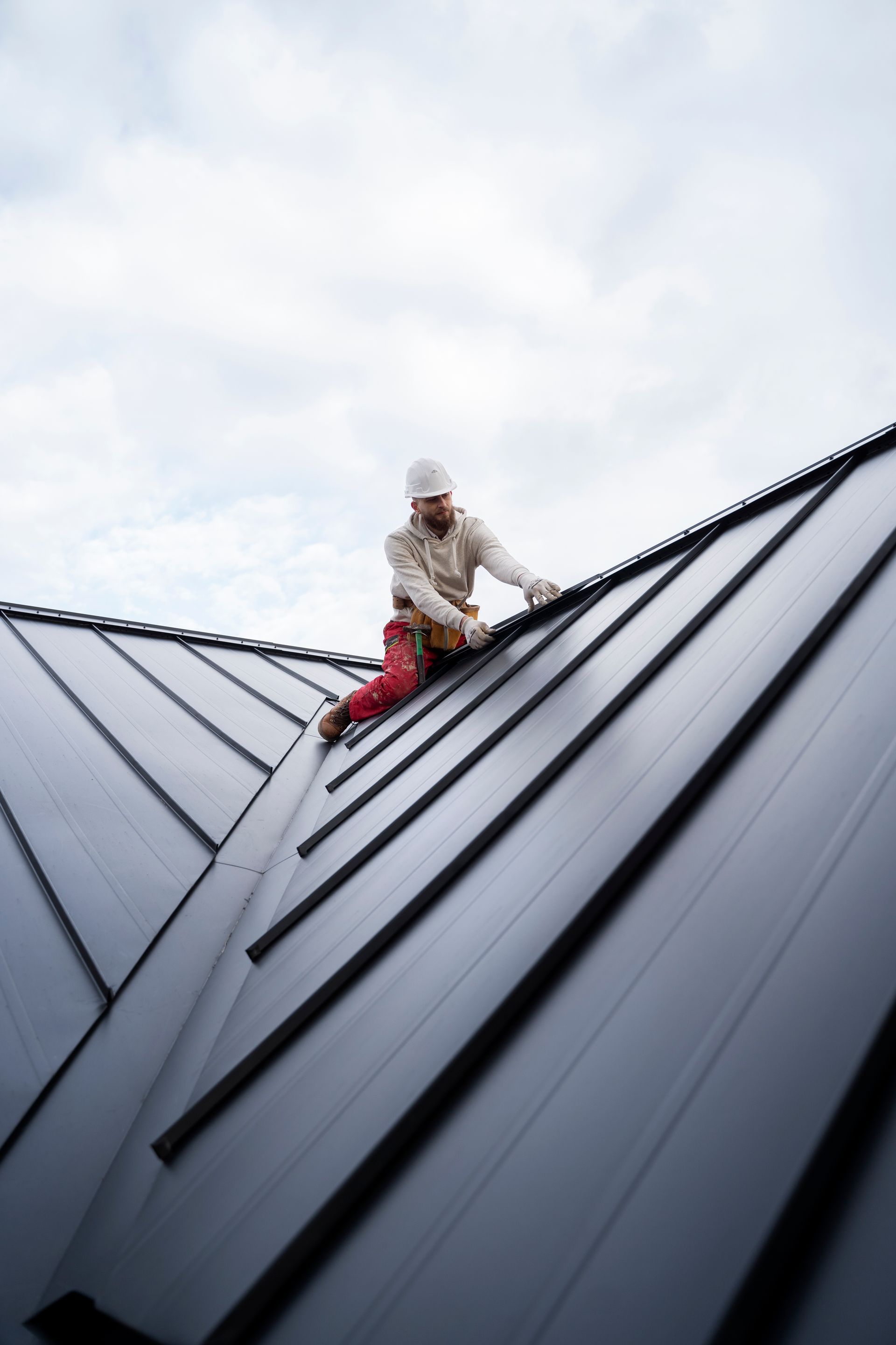 Roofing worker installing metal roof tiles